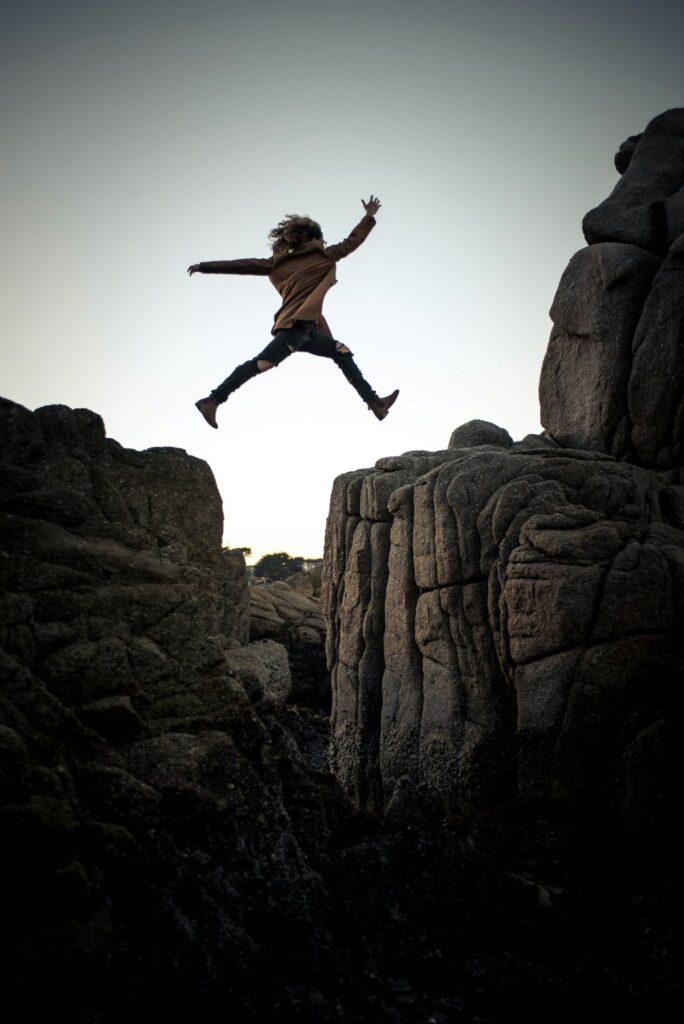 Chica saltando en la montaña